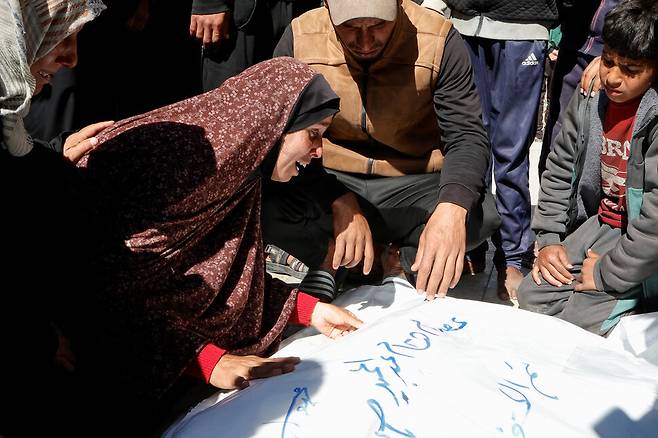 23일(현지시각) 가자 남부 칸 유니스 나세르 병원에서 이스라엘 공습으로 사망한 이들 곁에서 가족들이 슬퍼하고 있다. 칸유니스/로이터 연합뉴스