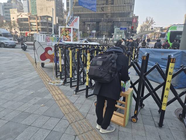 김형수 거제·통영·고성 조선하청지회장이 고공농성 중인 서울 중구 한화 본사 앞에서 한 시민이 김형수 지회장을 응원하는 연대 글을 적고 있다. 신다은 기자