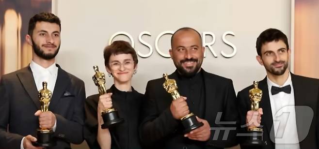 함단 발랄(오른쪽에서 두 번째) 감독이 올해 아카데미 시상식에서 상패를 들고 있는 모습. (유튜브 'NBC News' 갈무리)