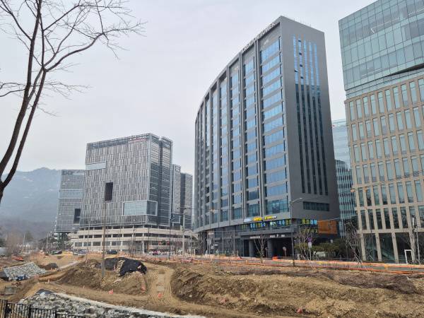 과천지식정보타운의 새로 지어진 건물 앞 공사 현장에서 토지 평탄화 작업 중인 모습.