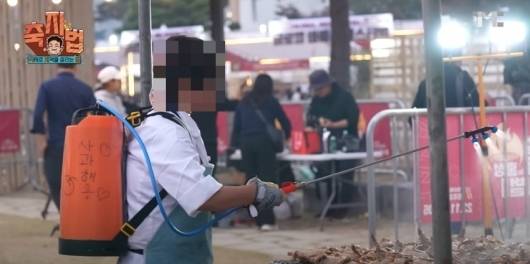 2023년 11월 열린 홍성글로벌바베큐축제에서 음식을 준비하던 직원이 식품용이 아닌 등짐 분무기(농약통)에 소스를 담아 고기에 살포하고 있는 모습. /사진=유튜브 채널 백종원 갈무리