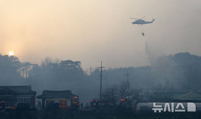 [정읍=뉴시스] 김얼 기자 = 25일 전북 정읍시 소성면에서 발생한 산불이 인근 마을까지 번지자 헬기로 화재를 진압하고 있다. 2025.03.25. pmkeul@newsis.com