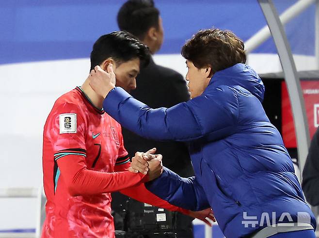 [수원=뉴시스] 김명년 기자 = 25일 경기 수원시 수원월드컵경기장에서 열린 2026 국제축구연맹(FIFA) 북중미 월드컵 아시아 지역 3차 예선 B조 8차전 대한민국과 요르단의 경기, 교체아웃된 손흥민이 홍명보 감독과 인사를 하고 있다. 2025.03.25. kmn@newsis.com