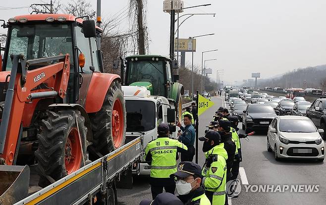 고속도로에서 트랙터 막아선 경찰 (서울=연합뉴스) 이진욱 기자 = 25일 경찰이 경부고속도로 양재나들목 부근에서 전국농민회총연맹(전농) 소속 트랙터의 진입을 막고 있다. 이날 전농은 서울 서초구 남태령고개에서 윤석열 대통령 탄핵 촉구 집회를 한 뒤 트랙터와 트럭을 이끌고 광화문 방면으로 행진할 계획이다. 2025.3.25 cityboy@yna.co.kr