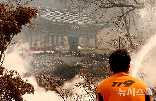 [의성=뉴시스] 김금보 기자 = 26일 대형 산불로 전소 피해를 입은 경북 의성군 단촌면 고운사에서 소방대원들이 진화작업을 하고 있다. 이번 산불로 고운사 보물인 연수전과 가운루를 비롯해 연지암, 해우소, 정묵당, 아거각, 약사전, 연수전, 고운대암, 극락전, 만덕당, 종무소가 불탔다. 2025.03.26. kgb@newsis.com