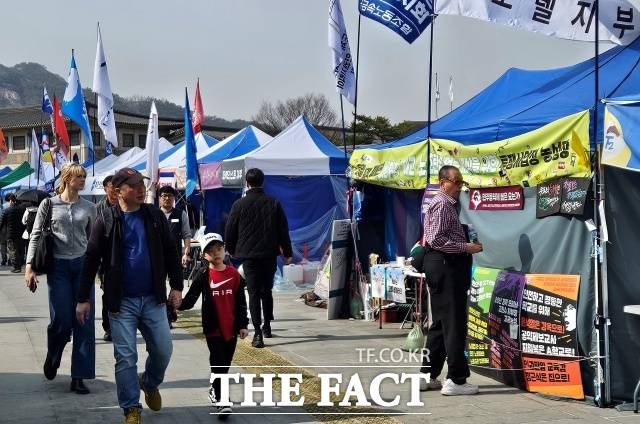 더불어민주당을 포함한 야5당이 윤석열 대통령 탄핵을 촉구하며 광화문 장외 투쟁을 이어가고 있다. 26일 외국인 관광객들이 광화문 일대에 설치된 천막 앞을 지나고 있다. /광화문=서다빈 기자