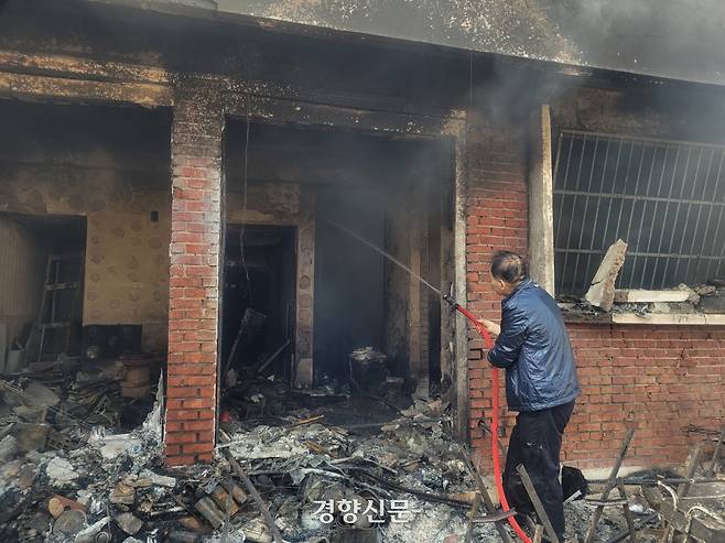 경북 영덕군 영덕읍 매정리에서 지난 26일 한 70대 남성이 자신의 집에 물을 뿌리고 있다. 백민정 기자