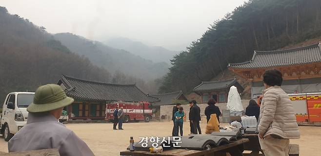27일 경남 산청군 삼장면 덕산사 관계자들이 연기가 나고 있는 지리산 능선을 바라보고 있다. 오른쪽 흰색 천에 쌓인 것이 삼층석탑(보물)이다. 김정훈 기자