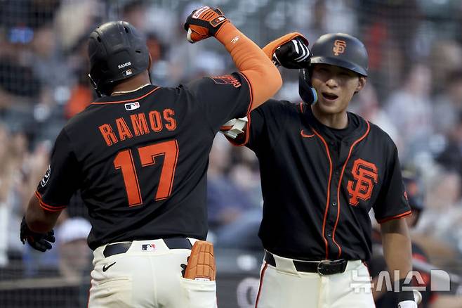 [샌프란시스코=AP/뉴시스] 샌프란시스코 자이언츠의 이정후(오른쪽)가 24일(현지 시간) 미 캘리포니아주 샌프란시스코의 오라클 파크에서 열린 디트로이트 타이거스와의 시범 경기 1회 말 1점 홈런을 치고 들어오는 엘리엇 라모스를 환영하고 있다. 이정후는 이날 3번 타자(중견수)로 선발 출장했다. 2025.03.25.