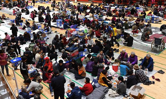 27일 오후 경북 영덕군 영덕읍 군민체육센터에서 지품면 등 산불 피해 이재민들이 대한적십자사 등 자원 봉사자들이 준비한 식사를 하고 있다. 뉴스1