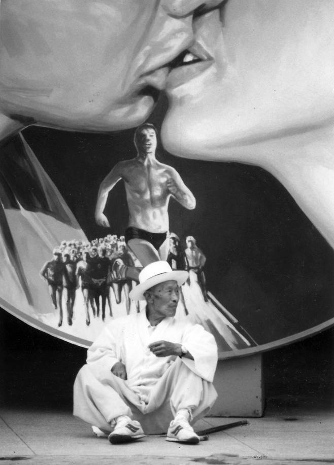 1985년 부산 남포동의 극장 앞에서 한 노인이 영화 간판 앞에 앉아있다/ 사진가 문진우