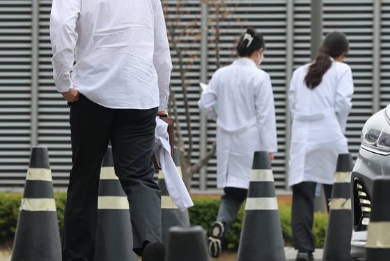 전남대와 조선대학교가 의대생 대규모 제적 사태를 피하기 위해 복학 신청서 접수기한을 28일까지 연장했다. 사진은 서울대학교 의과대학생의 등록 마감일인 전날 서울대병원에서 젊은 의료진이 이동하는 모습. [연합뉴스]