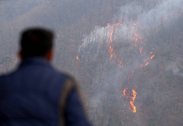 ▲ 27일 경북 의성군 옥산면 금봉저수지에서 주민이 번져나가는 산불을 바라보고 있다. 연합뉴스