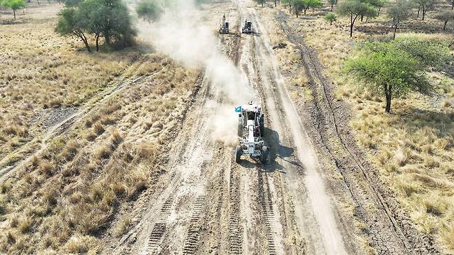 [서울=뉴시스] = 남수단재건지원단(이하 한빛부대)이  남수단의 항구적 평화를 위한 2013년 3월 31일 첫 파병으로부터 12주년을 맞았다고 합참이 밝혔다. 사진은 한빛부대 그레이더운용부사관이 주보급로 보수작전 간 그레이더를 운용해 지면을 평탄화 하는 모습. (사진= 합참 제공) 2025.03.30. photo@newsis.com *재판매 및 DB 금지