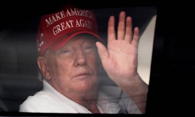 도널드 트럼프 미국 대통령이 29일(현지시간) 플로리다주 웨스트 팜비치의 골프장으로 이동하는 승용차 안에서 지지자들을 향해 손을 흔들고 있다. AP연합뉴스