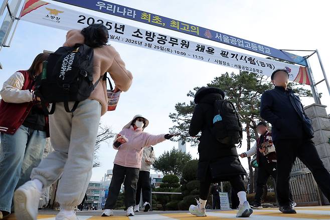 지난 3월 29일 한 고등학교에서 열린 2025년 소방공무원 채용 필기시험에 나선 응시생들이 시험장으로 향하고 있다. /뉴스1올해 채용 예정 인원은 총 1927명으로 전년 대비 244명 늘었으며 필기시험에 합격하면 체력시험, 종합적성검사, 면접시험, 신체검사와 서류전형을 거쳐 7월 18일 최종합격자 명단을 공고한다. 2025.3.29/뉴스1