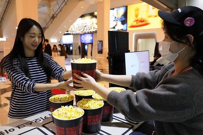 롯데온, 엘타운 론칭 기념 증정 팝콘을 들고 있는 모습