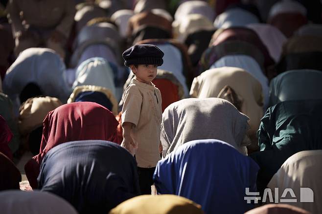 [쿠알라룸푸르=AP/뉴시스] 31일(현지 시간) 말레이시아 쿠알라룸푸르의 국립 모스크 마스지드 느라그에서 한 어린이가 이드 알피트르 기도를 올리는 사람들을 지켜보고 있다. 2025.03.31.