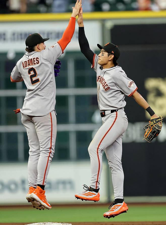 샌프란시스코 자이언츠 이정후가 1일(한국시각) 휴스턴 애스트로스와의 원정경기를 7대2로 승리한 뒤 유격수 윌리 아다메스와 하이파이브를 하고 있다. AFP연합뉴스