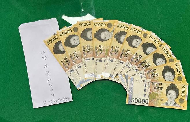 전북 전주시 완산구 효자동에 사는 김엘리사 씨(84)가 완산구청에 산불 피해 이재민을 돕기 위해 건넨 봉투와 5만 원권. 전주시 제공