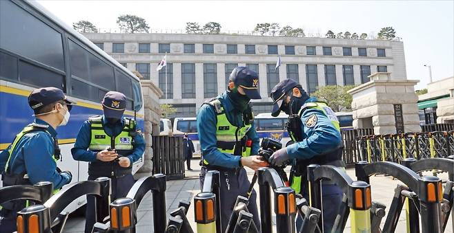 < 헌재 주변 긴장감 고조 >  헌법재판소가 윤석열 대통령 탄핵심판 선고일을 발표한 1일 서울 재동 헌재 앞에서 경찰이 바리케이드 주변을 점검하며 경계 근무를 서고 있다. 경찰은 선고 당일 안국역을 중심으로 찬반 집회 군중 사이에 ‘완충구역’을 설치하고, 일대를 사실상 진공 상태로 통제할 방침이다.  최혁 기자