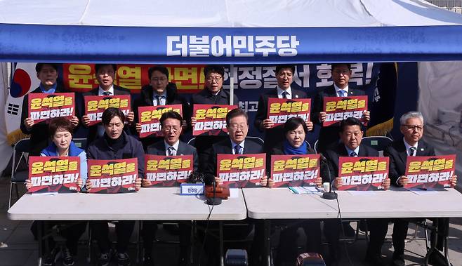 더불어민주당 이재명 대표를 비롯한 지도부가 31일 서울 종로구 광화문 앞 더불어민주당 천막당사에서 열린 최고위원회의에서 구호를 외치고 있다. 연합뉴스