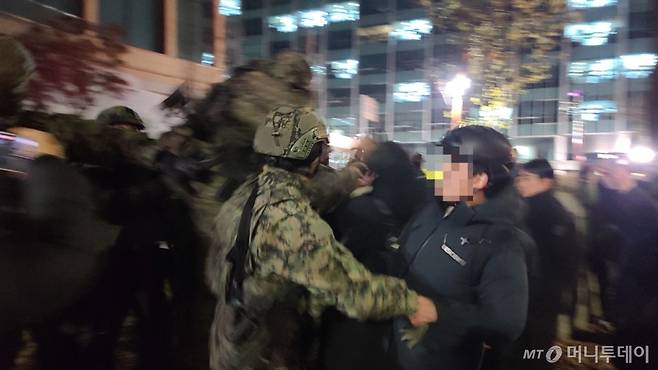 4일 오전0시 50분쯤 서울 여의도 국회의사당으로 진입하려는 군병력과 시민이 몸싸움을 벌이고 있다./사진=이찬종 기자