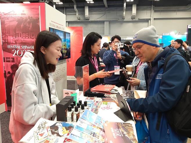 사우스 바이 사우스웨스턴(SXSW·사바사) 축제가 열리는 미국 텍사스주 오스틴시 오스틴컨벤션센터 1층에 마련된 부산 ‘페스티벌 시월’ 홍보관을 찾은 외국인이 홍보물을 찾고 있다. 김광수 선임기자