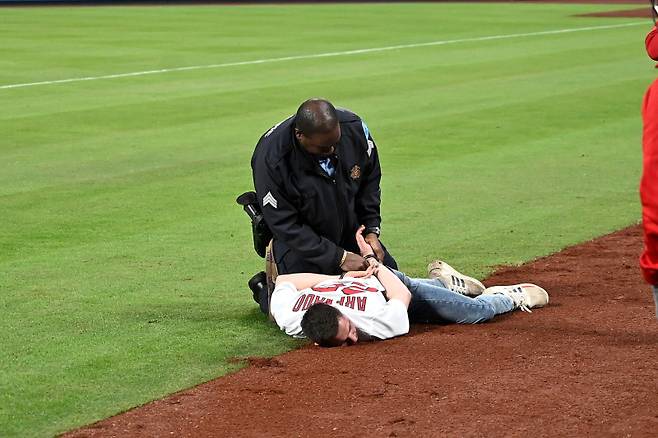 <yonhap photo-4653="">지난 28일(한국시간) 미네소타와의 개막전이 열린 부시스타디움에 야구팬이 난입, 경찰에 체포되고 있다. [AFP=연합뉴스]</yonhap>