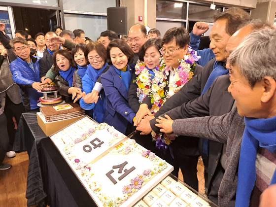 변광용 거제시장 당선인(오른쪽에서 4번째)이 2일 오후 경남 거제시 고현동 선거사무실에서 당선이 확정되자 꽃다발을 목에 걸고 아내인 김옥숙씨, 지지자들과 함께 당선 케이크를 자르고 있다. 사진 더불어민주당 경남도당