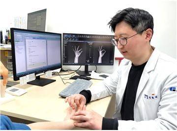 센텀종합병원 정형외과 김호진 과장이 ‘방아쇠 수지’ 질환자를 진료하는 모습. 센텀종합병원 제공