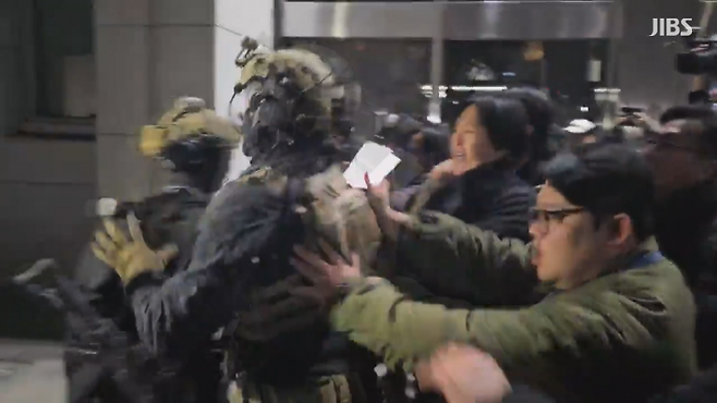 지난해 12월 3일 밤 국회에 진입한 계엄군이 시민과 대치하고 있다.