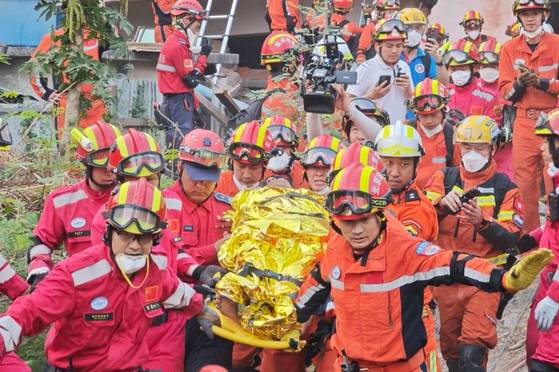 2일(현지시간) 미얀마 만달레이에서 같은 호텔에서 현지와 중국 구조대원들의 구호활동 아래 또다른 26세의 남성이 구조되고 있다. 신화=연합뉴스