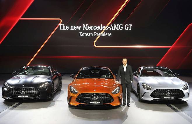 Mercedes-Benz Korea CEO, Mathias Vaitl, poses with the Mercedes-AMG GT 63 S E Performance (center) and two Mercedes-AMG GT 55 4MATIC+ models after the opening ceremony of the brand's booth at the 2025 Seoul Mobility Show in Goyang, Gyeonggi Province, Thursday. The fully redesigned coupes feature upgraded motorsports technology and enhanced usability compared to the previous GT lineup. (Mercedes-Benz Korea)