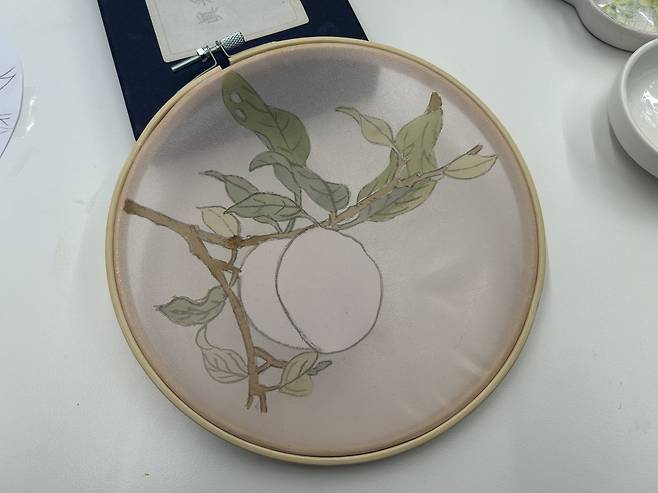 In the process of making my first jinchae, (silk painting), I tried baechae, or the traditional technique of coloring on the back of the sheer silk. Here, I flipped over my painting back to the front after coloring the back of the peach in white. [SHIN MIN-HEE]