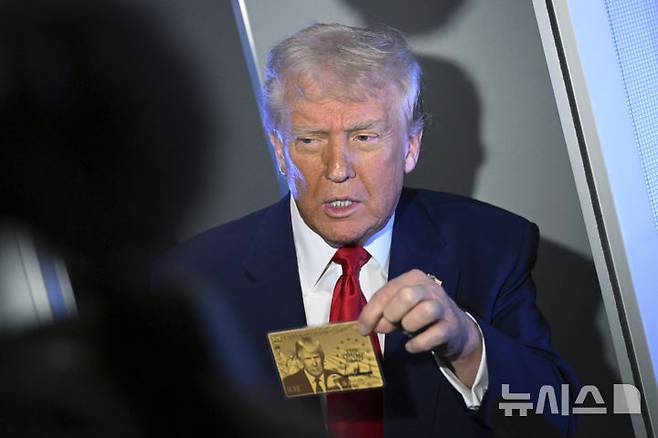 [에어포스원=AP/뉴시스] 도널드 트럼프 미국 대통령이 3일(현지 시간) 플로리다 마이애미로 향하는 에어포스원에서 취재진에 '골드 카드'를 들어 보이고 있다. 2025.04.04.