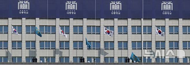 [서울=뉴시스] 조수정 기자 =  헌법재판소가 윤석열 대통령의 탄핵사건에 대해 인용을 선고한 4일 서울 용산 대통령실 청사에서 관계자들이 봉황기를 하기하고 있다. 2025.04.04. chocrystal@newsis.com