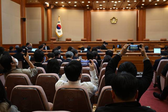 ▲4일 서울 종로구 헌법재판소 대심판정에서 열린 윤석열 대통령 탄핵심판 선고에서 방청객이 휴대전화로 사진찍고 있다. ⓒ연합뉴스