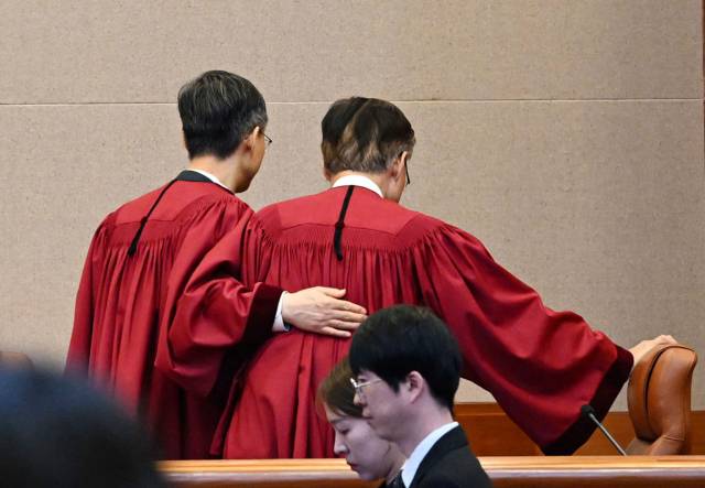 문형배 헌법재판소장 권한대행(왼쪽)이 4일 서울 종로구 헌법재판소 대심판정에서 윤석열 대통령 탄핵심판 인용 결정을 선고한 뒤 김형두 재판관과 대심판정을 나서고 있다. 사진공동취재단