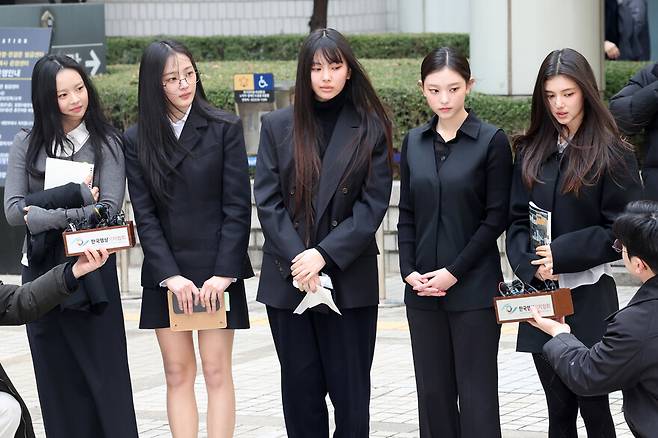 아이돌 그룹 엔제이지(NJZ, 옛 뉴진스)가 2025년 3월7일 서울 서초구 서울중앙지법에서 열린 어도어의 광고 계약 체결 금지 및 기획사 지위보전 가처분 사건 첫 심문기일에 참석한 뒤 법원을 나서며 취재진의 질문에 답하고 있다. 왼쪽부터 하니, 민지, 혜인, 해린, 다니엘. 한겨레 김영원 기자 forever@hani.co.kr
