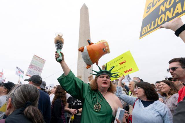 5일 미국 수도 워싱턴의 워싱턴 기념탑에서 자유의 여신상으로 분장한 한 시민이 도널드 트럼프 대통령의 정책과 전횡에 반대하는 “손을 떼라!” 집회에 참여하고 있다. 워싱턴=AP 연합뉴스