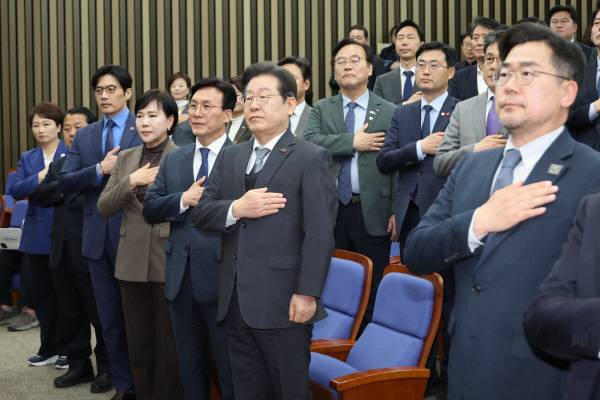 더불어민주당 이재명 대표와 박찬대 원내대표를 비롯한 의원들이 4일 서울 여의도 국회에서 열린 의원총회에서 국기에 경례하고 있다. 연합뉴스