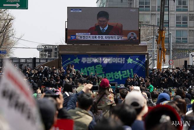 4월4일 서울 안국역 인근에 모인 시민들이 대형 전광판에서 나오는 윤석열 탄핵 선고 방송을 지켜보고 있다. ⓒ시사IN 이명익