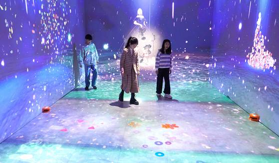 소중 학생기자단이 실감 콘텐트 미디어아트 체험을 하며 문양을 이용한 텍스타일 디자인 개념을 느끼고 있다.