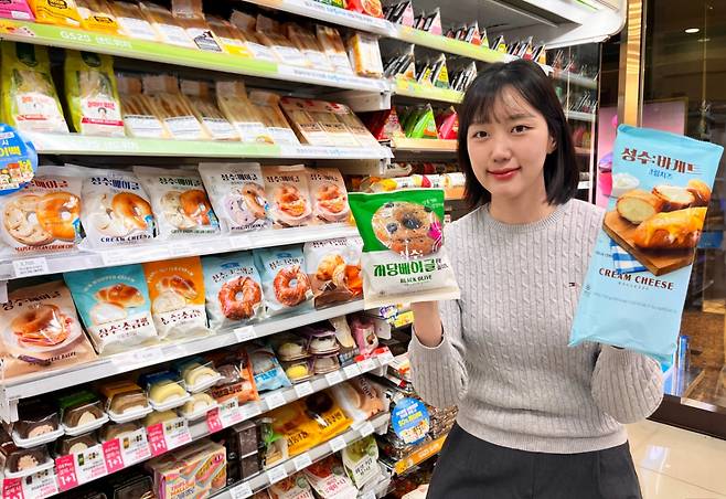 GS25에서 모델이 성수 시리즈 상품을 들고 포즈를 취하고 있다. /사진제공=GS리테일