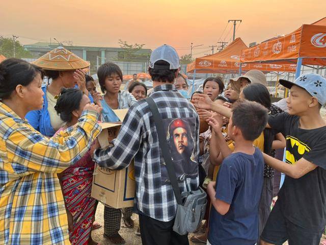 2일 지진으로 집을 잃은 이들을 위해 마련된 미얀마 만달레이 텐트촌에서 한 봉사자가 생필품이 담긴 박스를 꺼내 들자 시민들이 몰려들고 있다. 만달레이=허경주 특파원
