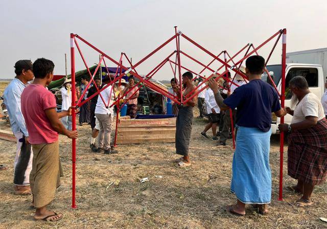 지난 4일 미얀마 만달레이에서 남서쪽으로 13㎞ 떨어진 이슬람 교인 마을 본우에에서 지진을 피해 인근 공터로 피신한 무슬림 시민들이 자원봉사자들이 기부한 천막을 설치하고 있다. 본우에=허경주 특파원