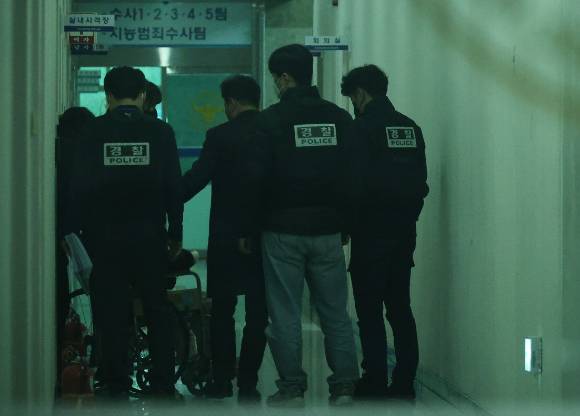 지난달 7일 대전서부경찰서에서 첫 대면조사를 마친 대전 초등생 살해 교사 명모(40대) 씨가 조사실을 나오고 있다. 경찰들이 명씨를 유치장에 입감하기 위해 이동시키고 있다. [사진=연합뉴스]