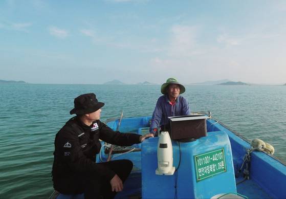 국방부 유해발굴감식단 관계자가 지난해 10월 충남 서산시 팔봉면 고파도 인근 바다에서 주민으로부터 남아공 조종사 실종 관련 증언을 청취하고 있다. 국방부 유해발굴감식단