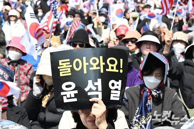 지난 4일 서울 용산구 한남동 대통령 관저 앞에서 탄핵 반대 집회 한 참가자가 윤석열 전 대통령의 복귀를 바라는 피켓을 들고 있다. 기사 내용과 직접적 관련 없음. 황진환 기자
